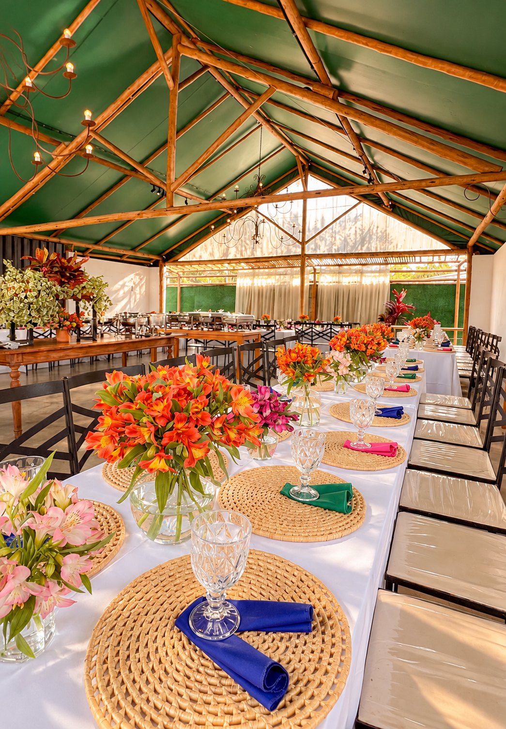 Mesa longa decorada com flores laranja e sousplat de palha