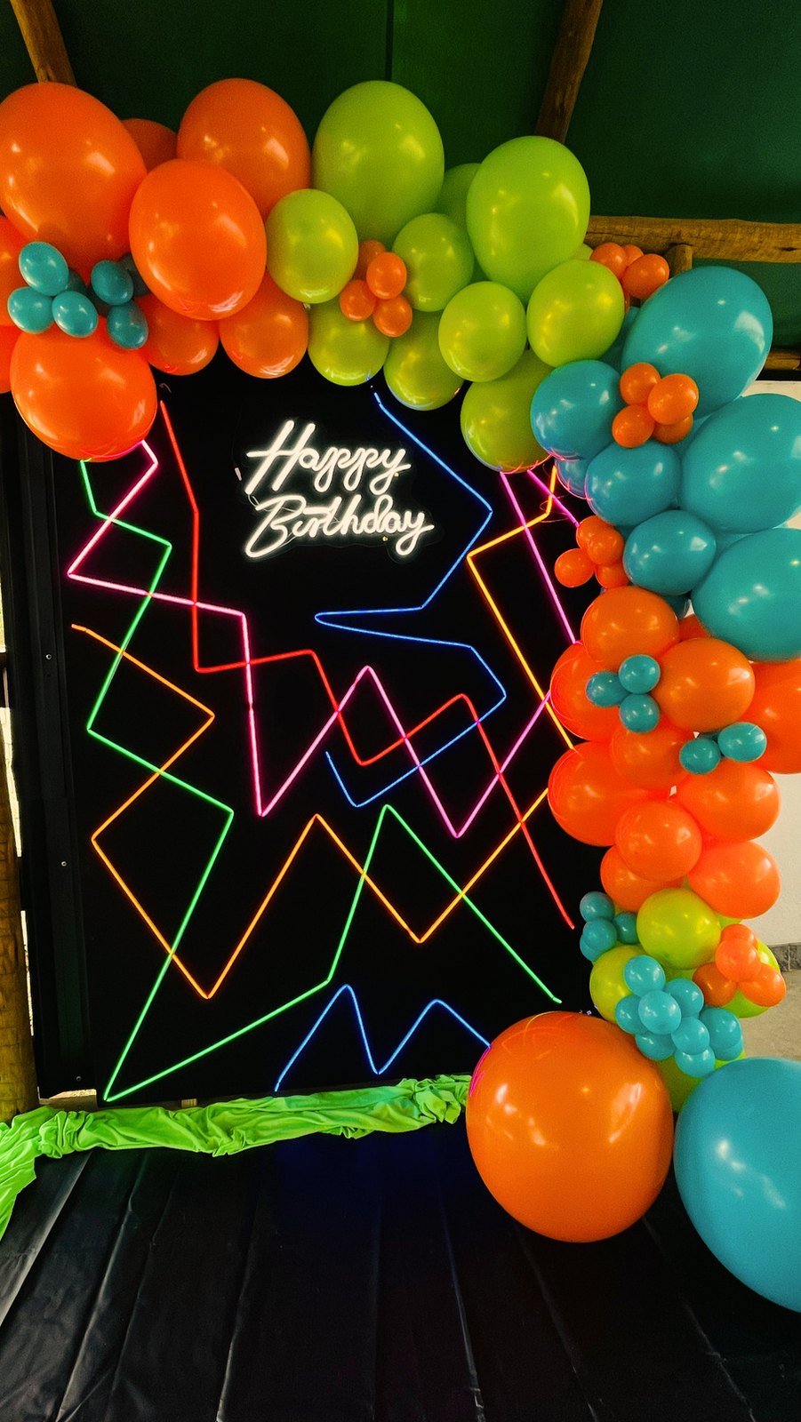 Painel de balões coloridos com letreiro neon Happy Birthday