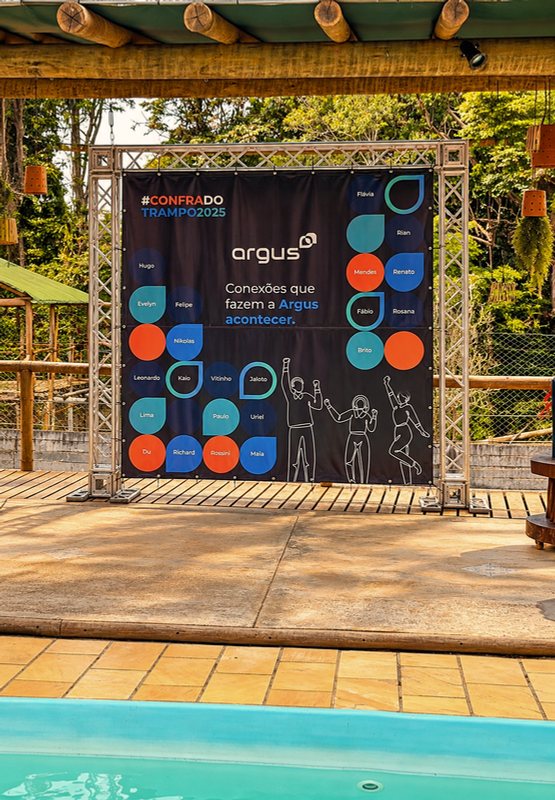 Backdrop com a arte da empresa ao lado da piscina