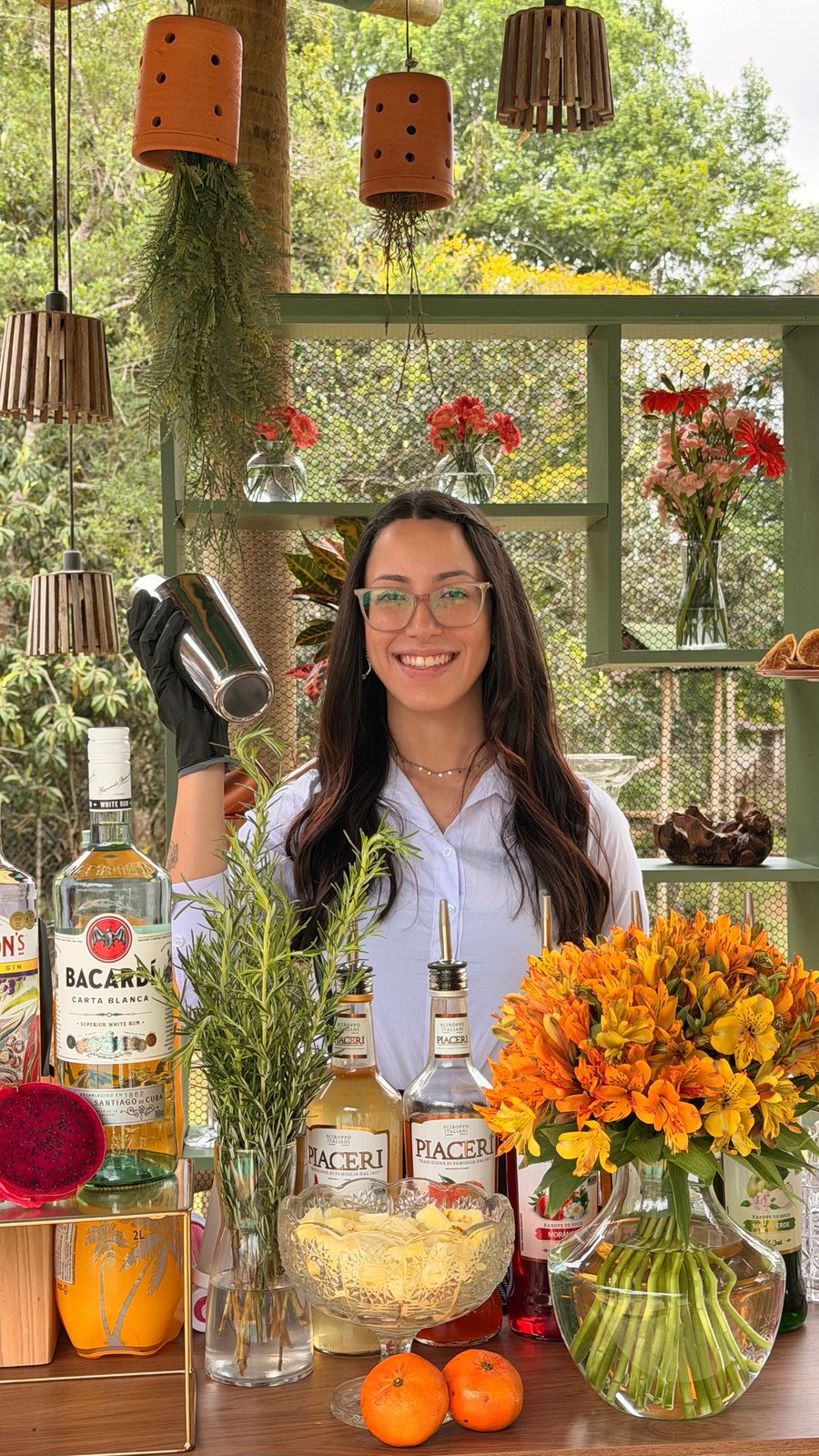 Bartender com garrafas e flores no bar