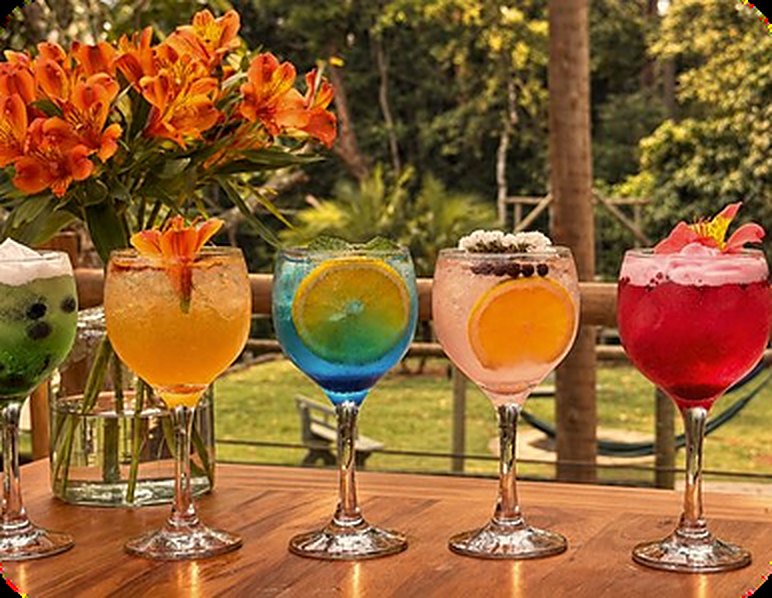 Taças de drinks coloridos sobre a mesa de madeira